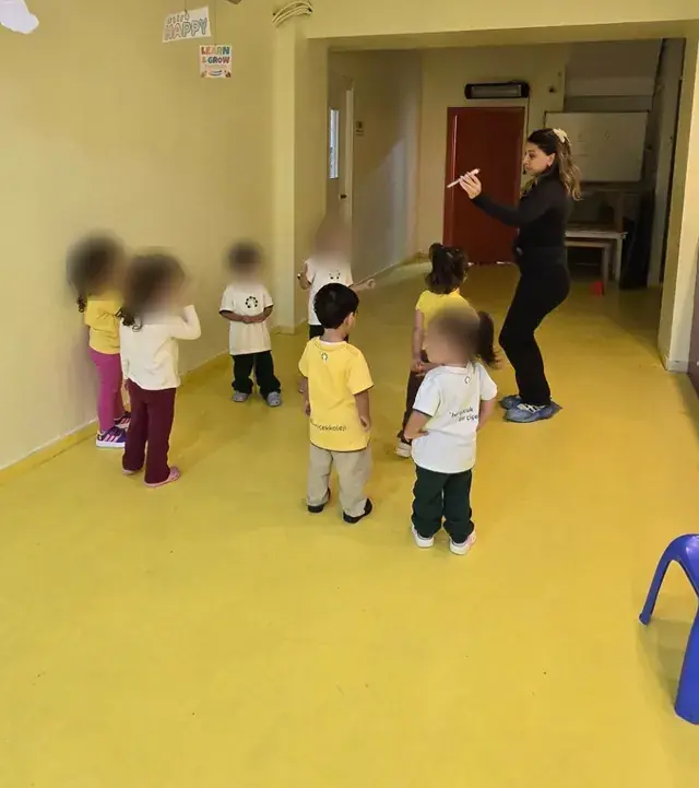 Jimnastik dersinde öğretmenin yönergeleriyle hareket eden çocuklar