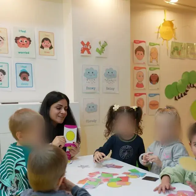 İngilizce etkinliğinde öğretmenin gösterdiği kartı izleyen çocuklar
